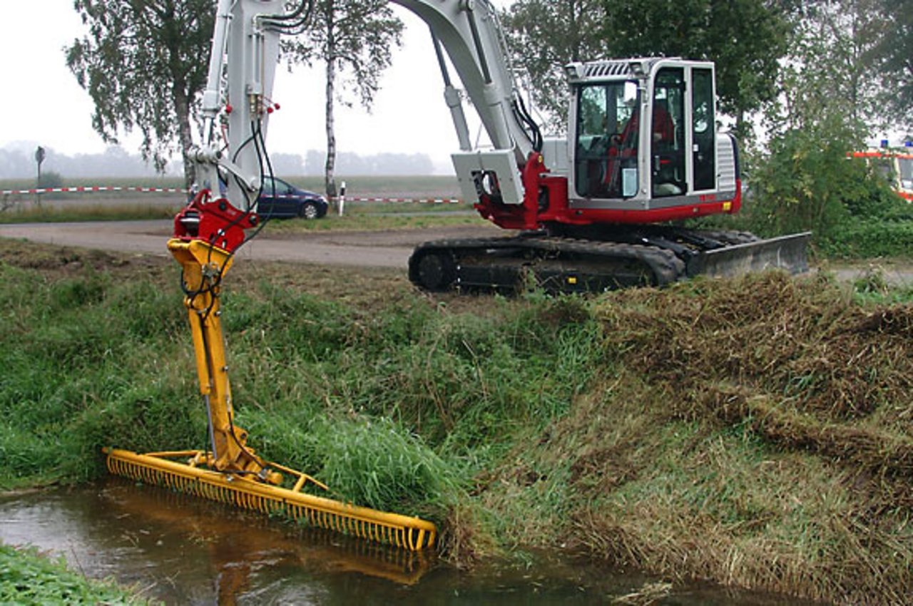 Bagger mit Mähkorb am Ufer